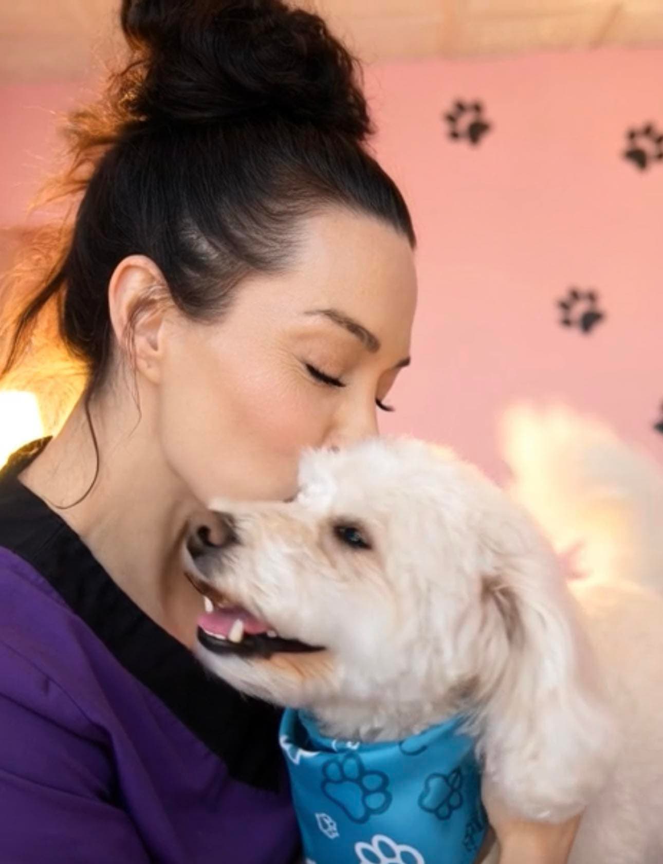 LilaJean cuddling a freshly groomed white dog at The Paw Queen grooming salon in Boulder City, NV